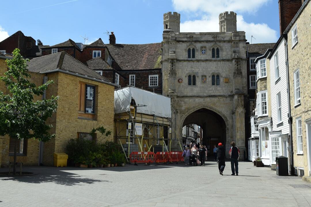 Historic gatehouse with buildings and people walking