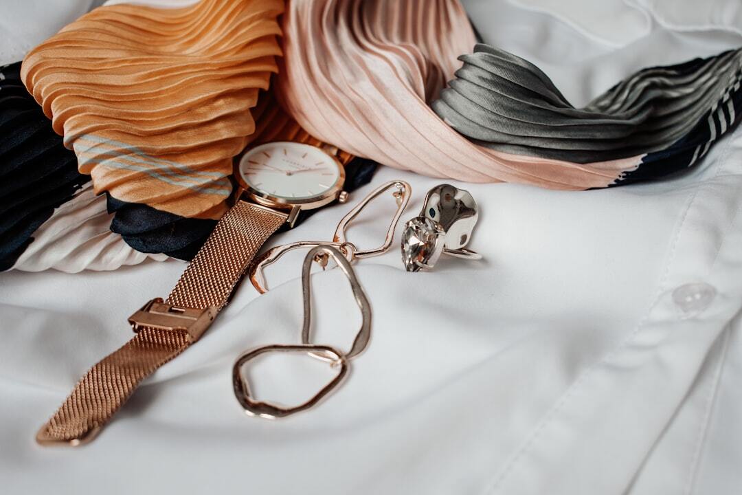 Round white and gold-coloured analog watch with gold-coloured milanese band