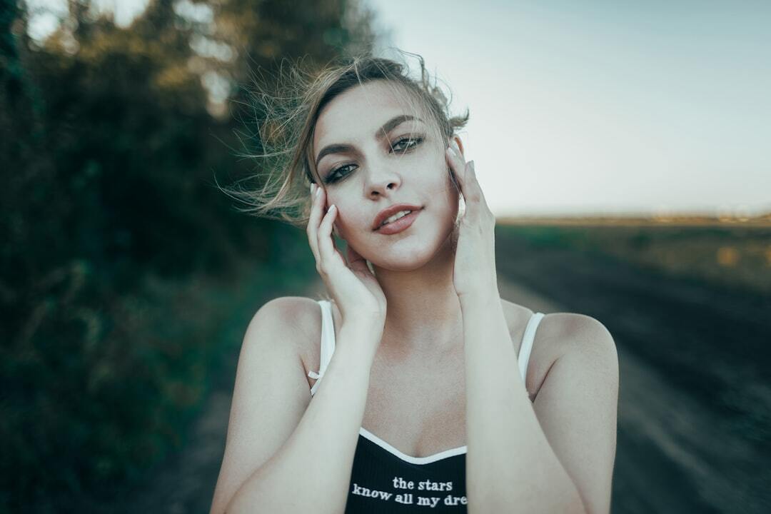 Young woman with hands on cheeks in field