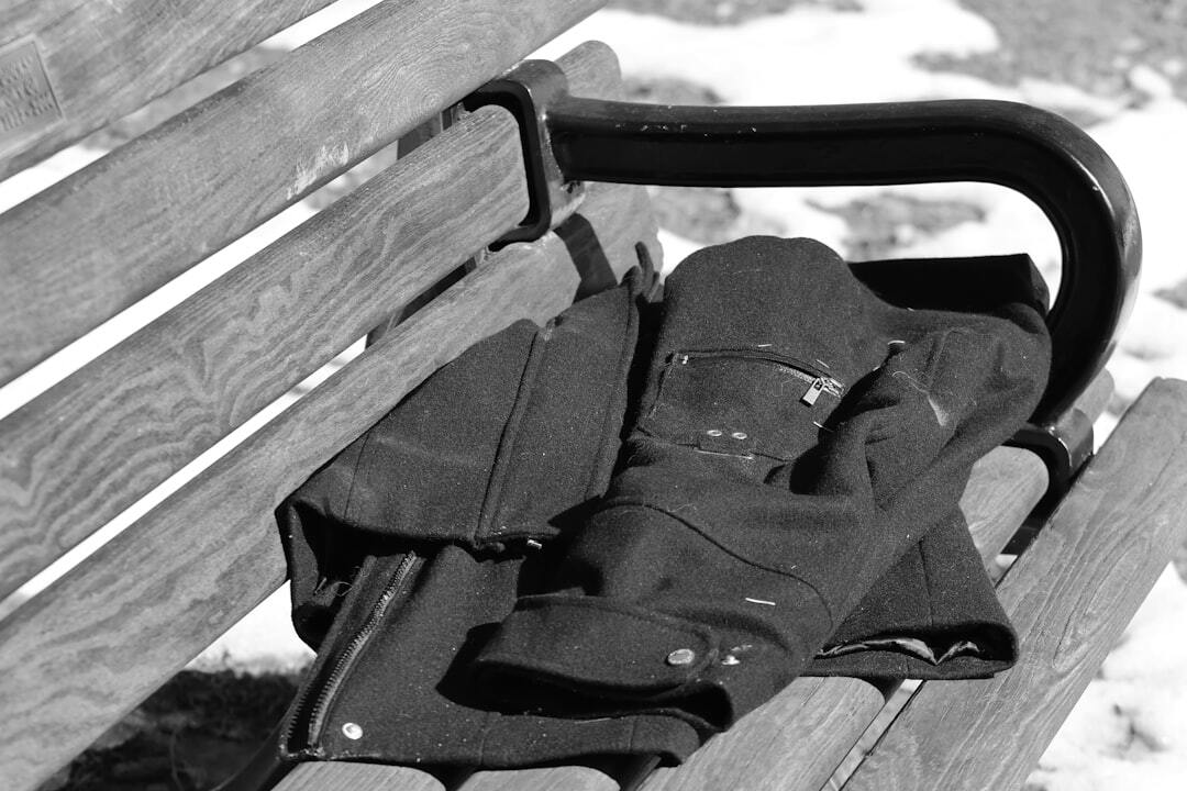 A jacket rests on a wooden park bench