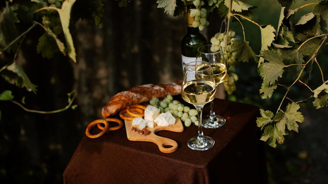 A table topped with a glass of wine and a plate of food