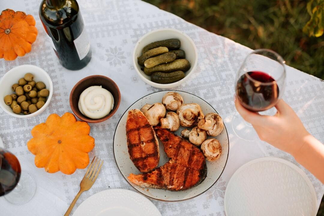 A table topped with plates of food and a glass of wine