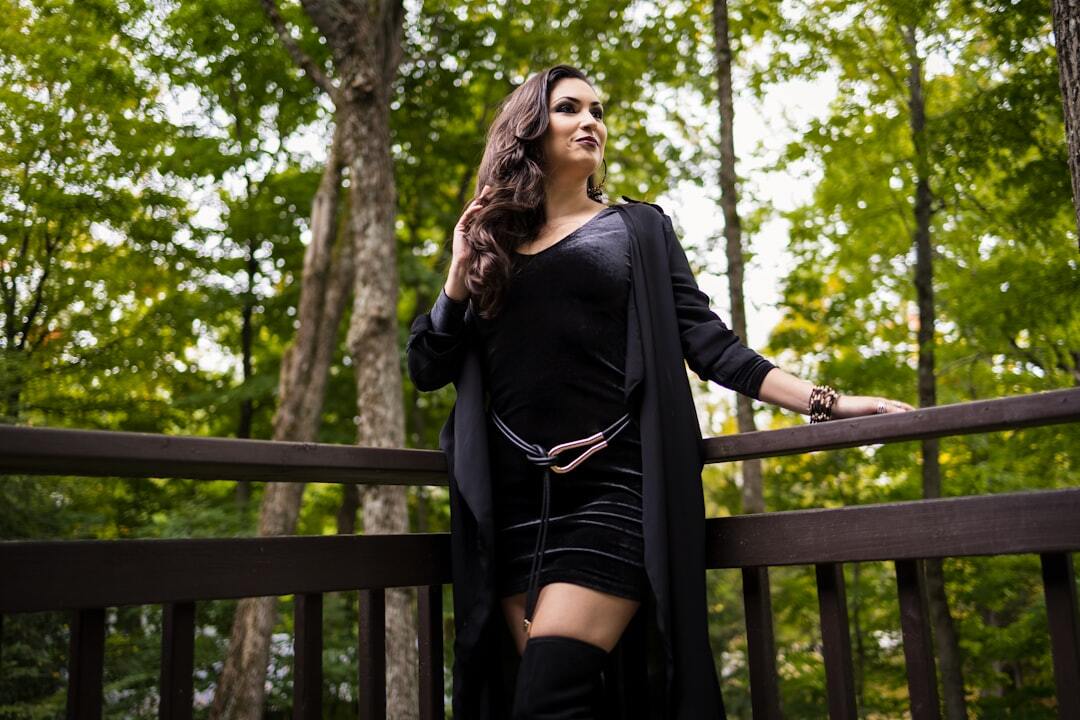 Elegant woman stands on a deck in a green forest