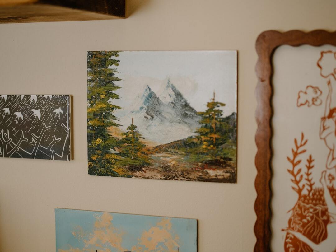 Painting of mountains with evergreen trees